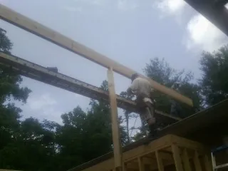 Carpenter setting a ridge beam over a new addition frame — Ice Dam Removal by Roofing Brothers in Issaquah