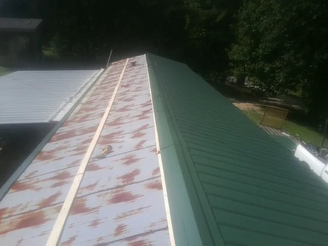 Old rusted panels beside newly installed green metal roofing — Wind Damage Roof Repair by Roofing Brothers in Issaquah